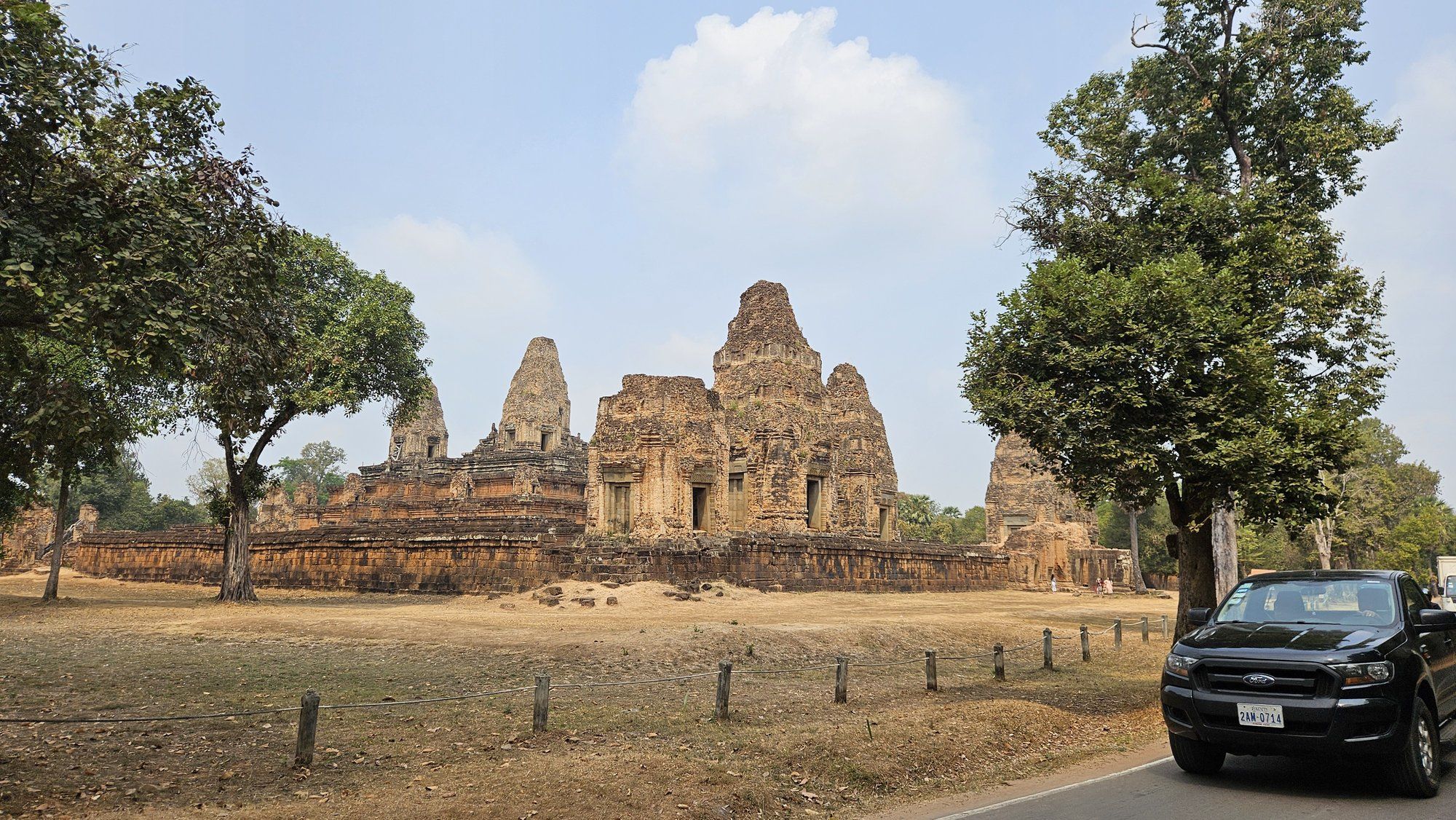 A car parked beside a temple on the Angkor circuit