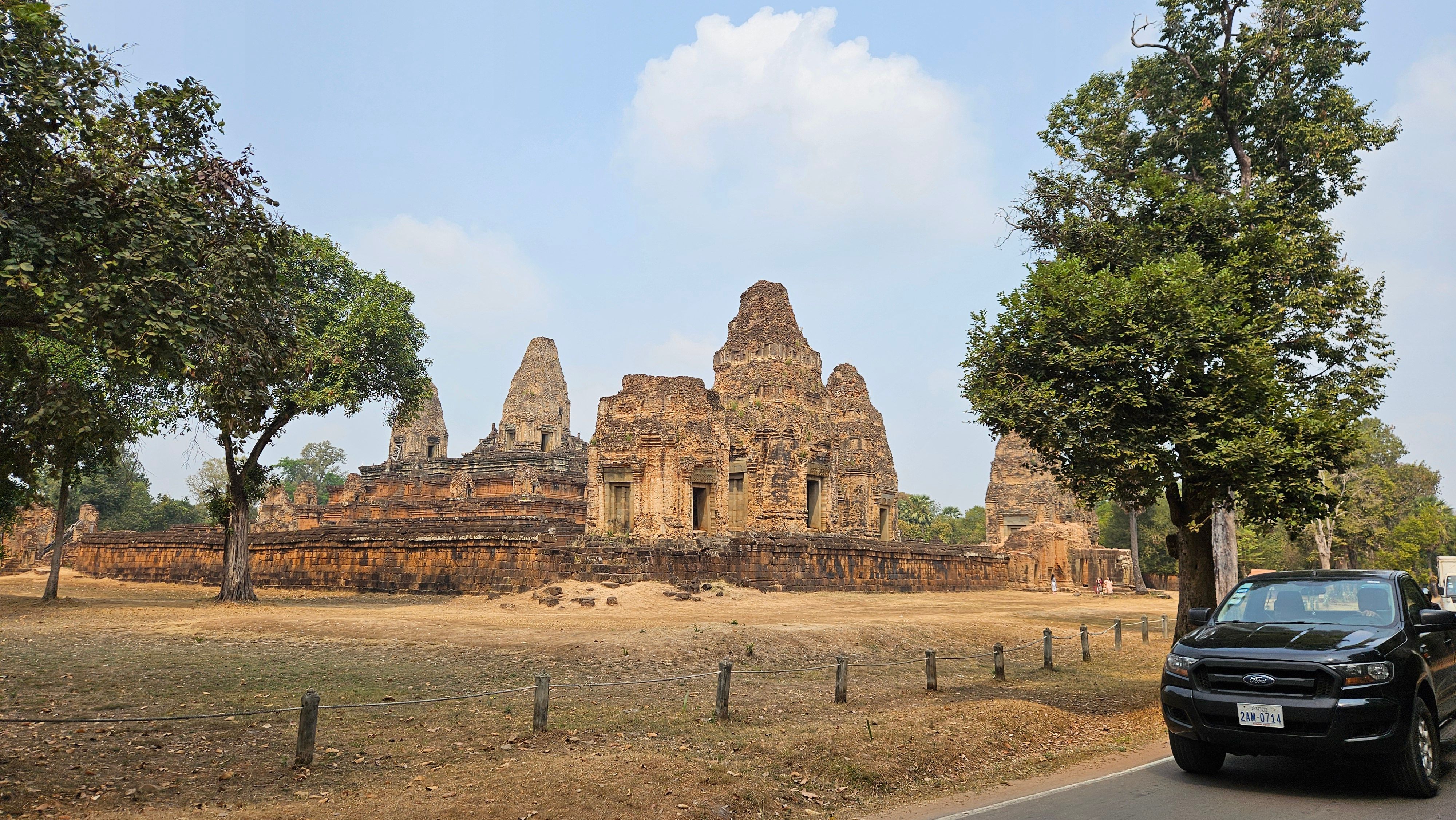 A car parked beside a temple on the Angkor circuit