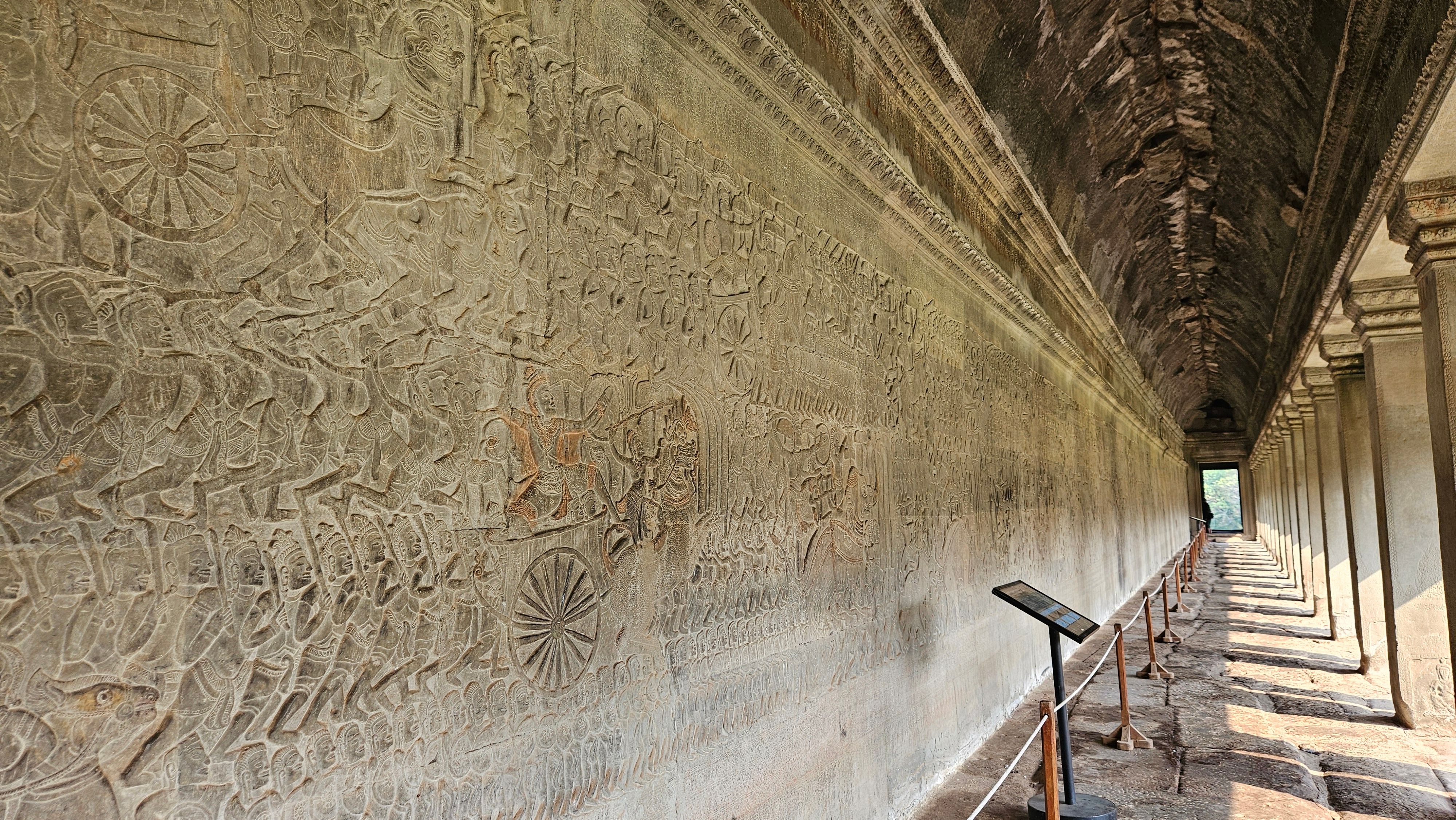 The bas-relief gallery of Angkor Wat, its carved wall running the length of the corridor