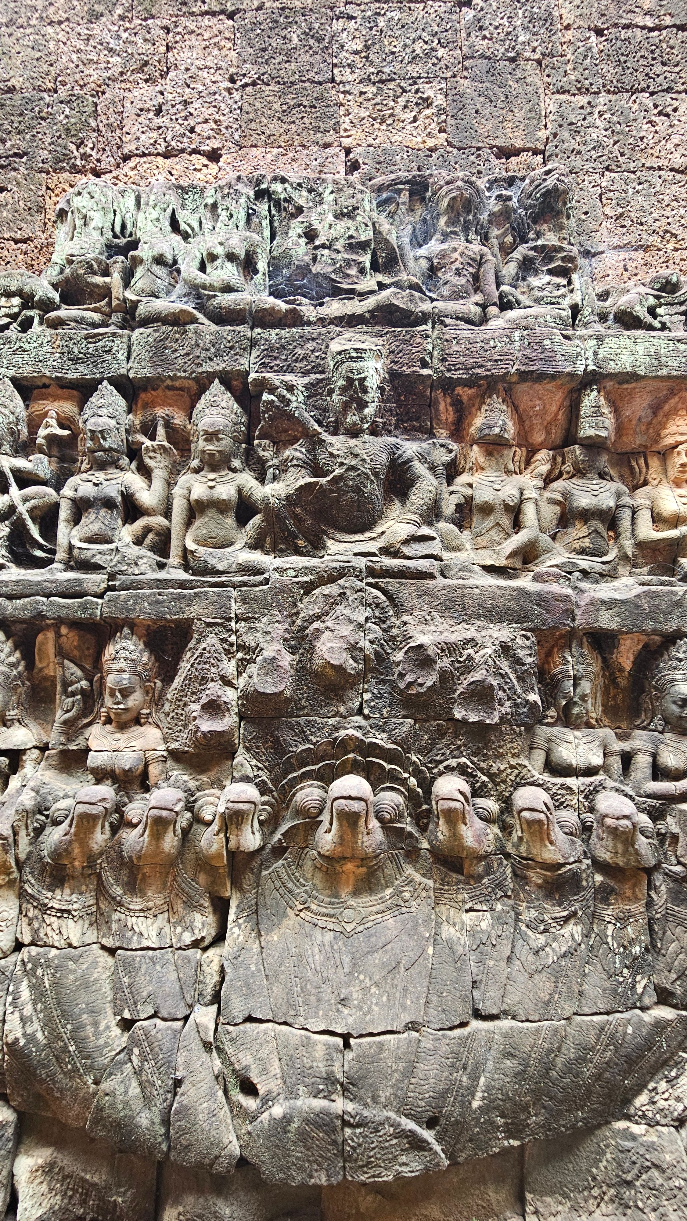 A row of carved devata figures on a temple wall