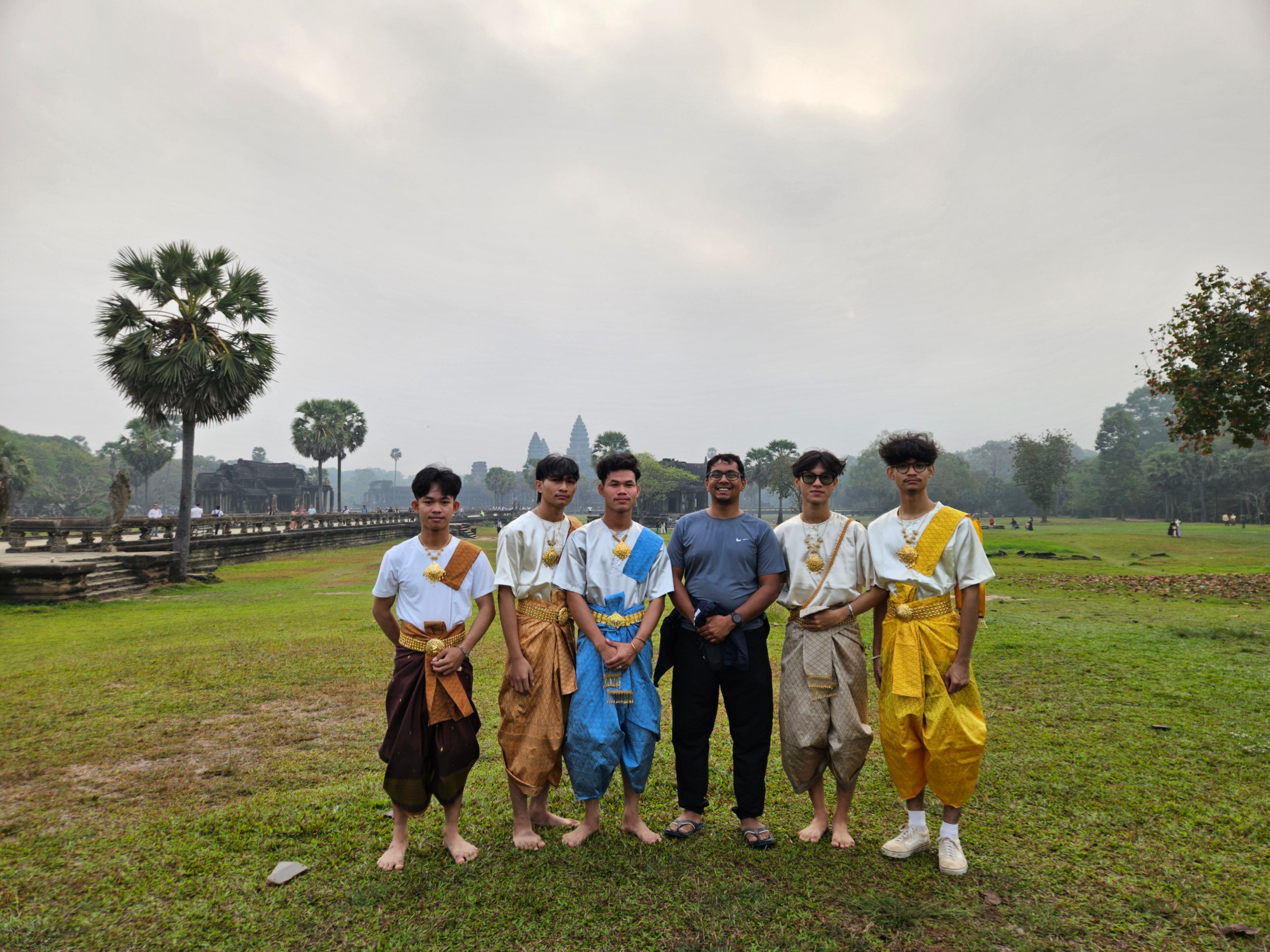 A group of young Cambodian groomsmen in traditional Khmer dress in front of Angkor Wat