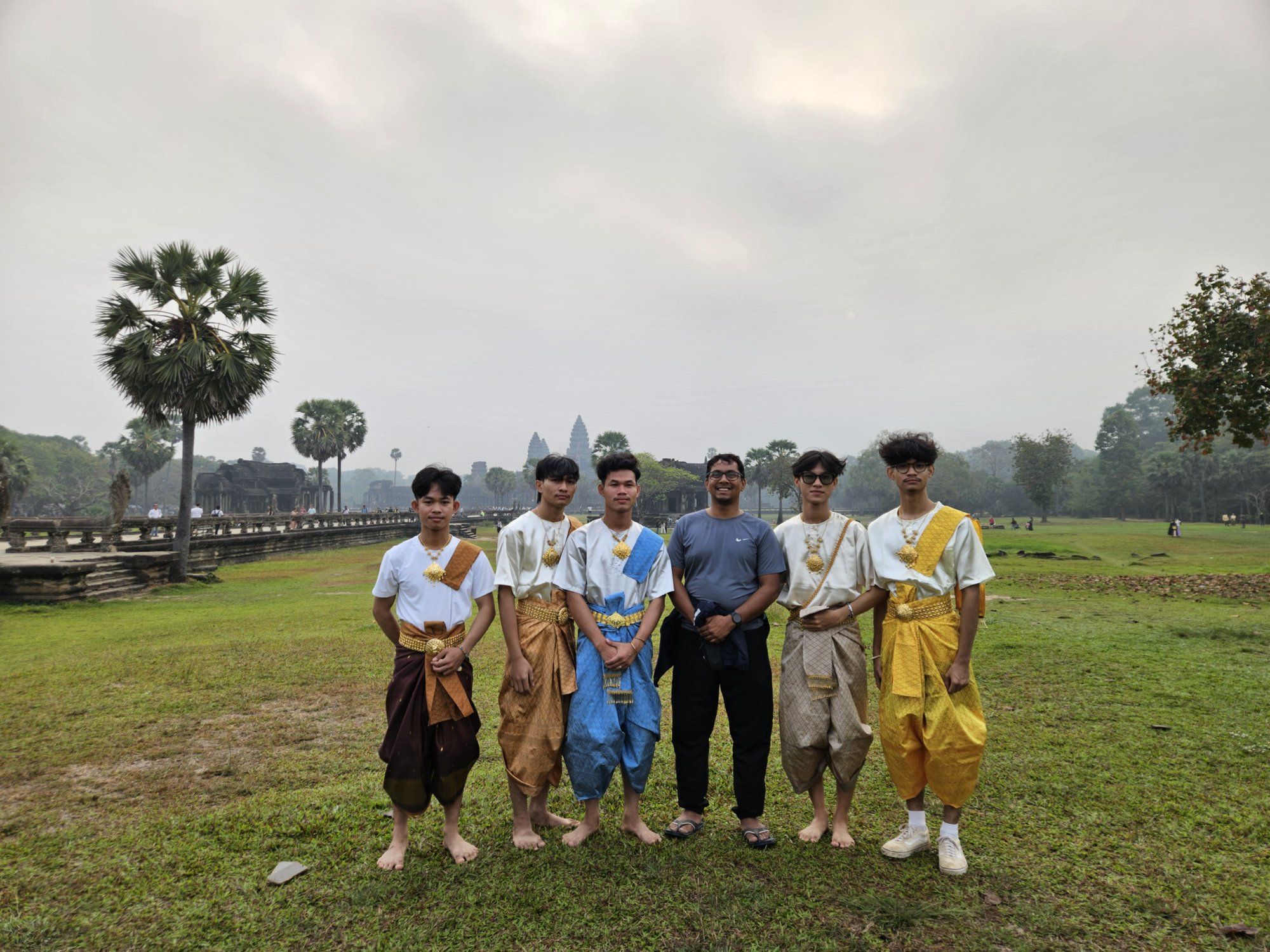 A group of young Cambodian groomsmen in traditional Khmer dress in front of Angkor Wat