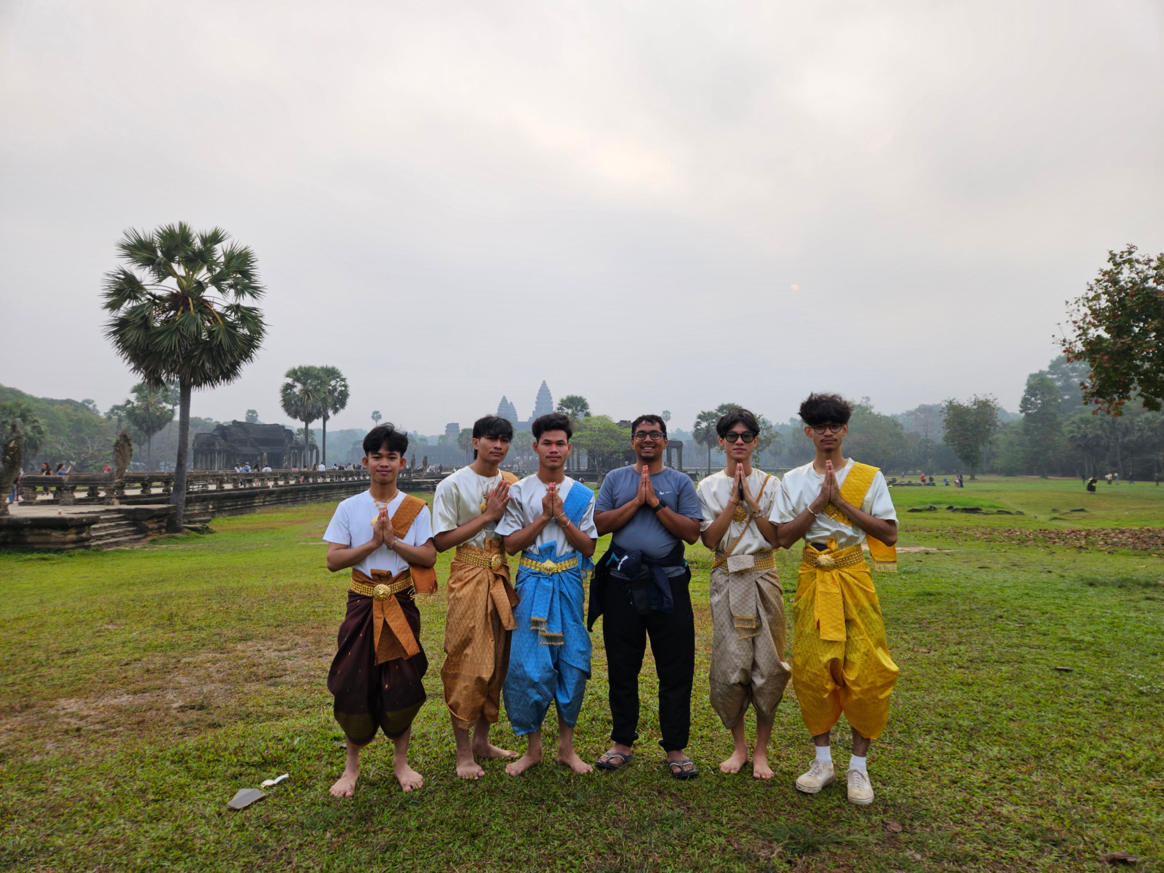 Young Cambodian men in traditional Khmer dress at Angkor Wat at dawn