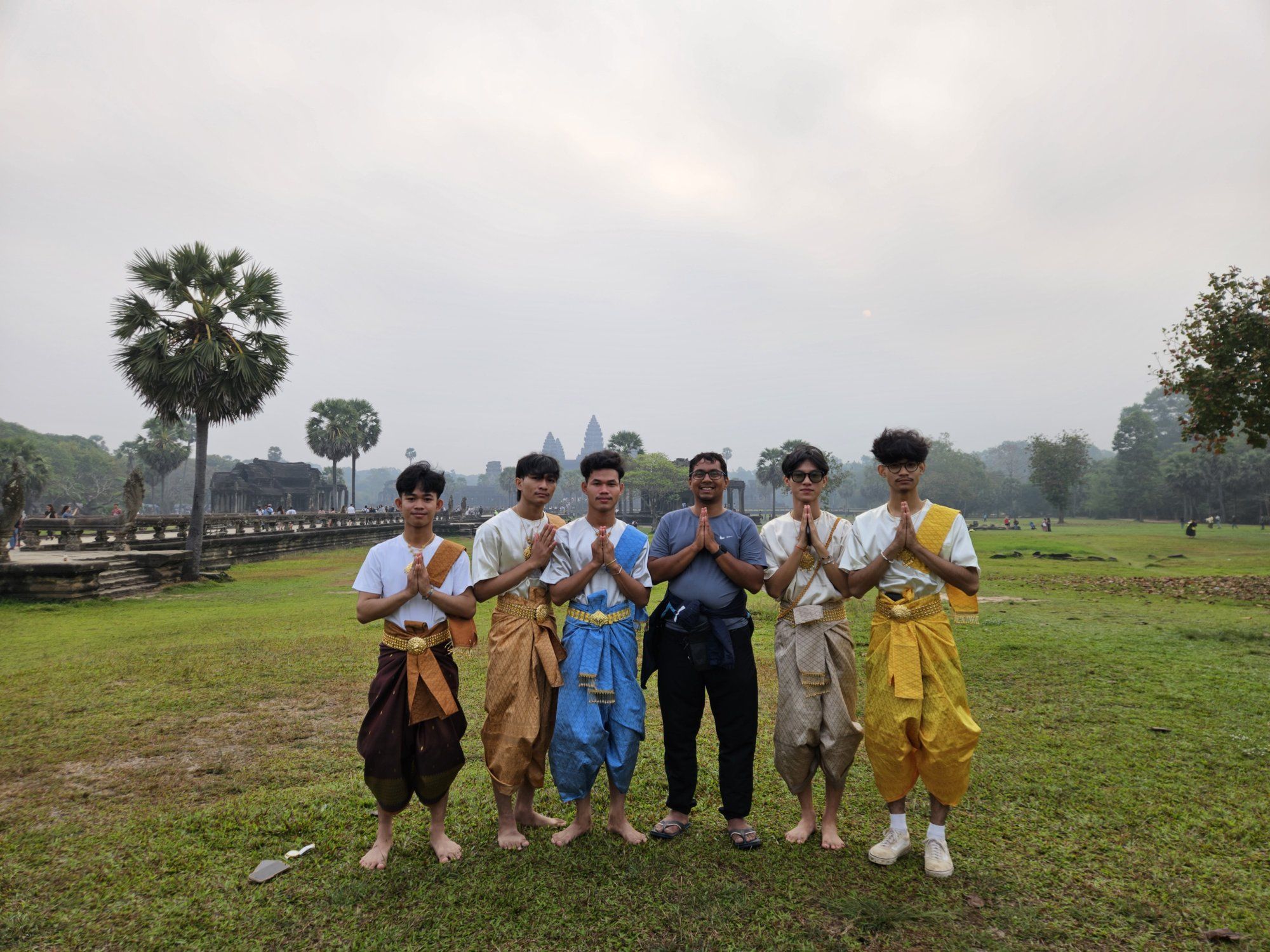 Young Cambodian men in traditional Khmer dress at Angkor Wat at dawn